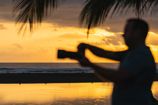 Photographer on beach at sunset