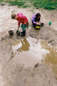 Kids play in spring mud puddle