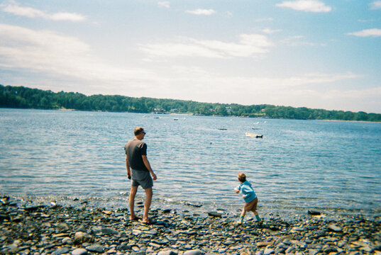 Father and son skip rocks together