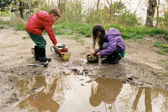 Siblings play outside in spring