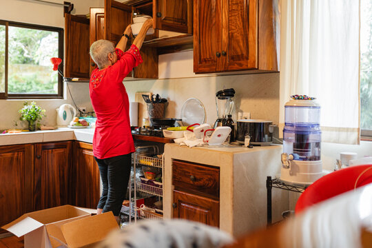 Woman organizing kitchen cabinets