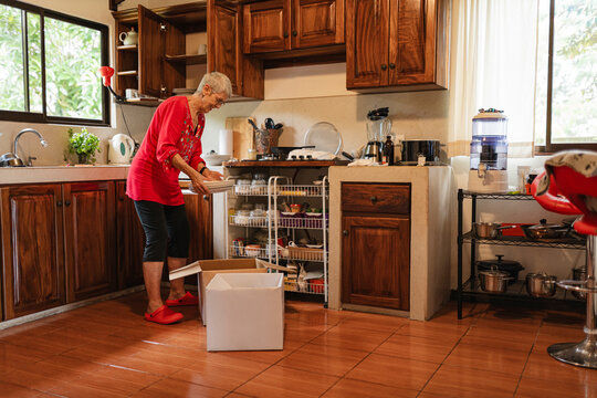 Senior woman packing dishes in kitchen