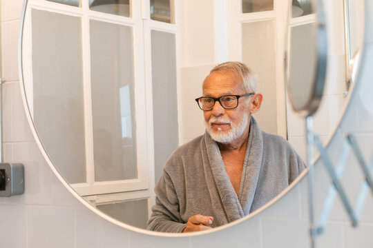 Man in Bathrobe Looking Mirror