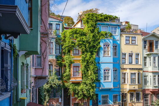Colorful historic houses with lush ivy on the facade in Balat against blue sky with clouds in Istanbul, Turkey