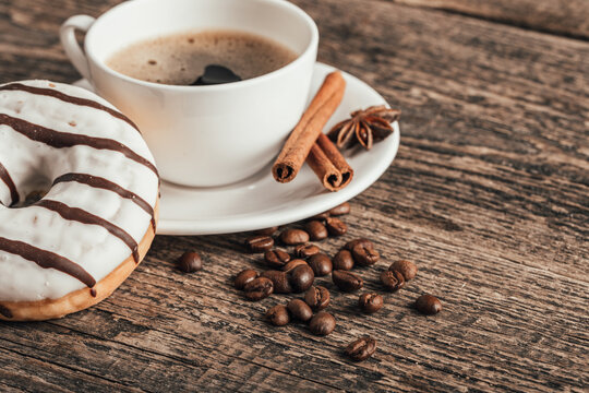 Sweet chocolate donut with coffee on wood background.