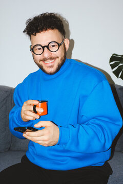 Smiling Man with Coffee and Phone
