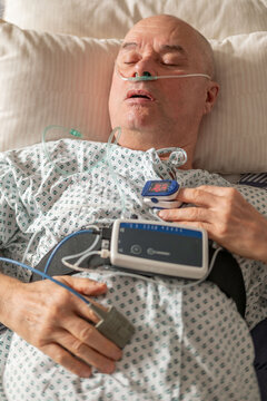 Senior male patient in hospital, oxygen mask respiratory support, clinical ventilation interface obstructive sleep apnea treatment, medical breathing equipment in hospital, Postoperative monitoring