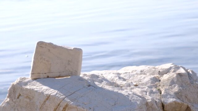 Calm sea tranquil ethereal view. Stone pyramide, podium.  Empty template for text. Harmony, relax, meditating, mental health concept. Dreamy scenery. Water splash. Pure water with reflections sunlight