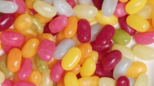 Colorful small jelly candies moving randomly in stop motion. . Seamless loop. Playful and vibrant background for candy, desserts, kids products, food advertising, and festive mood
