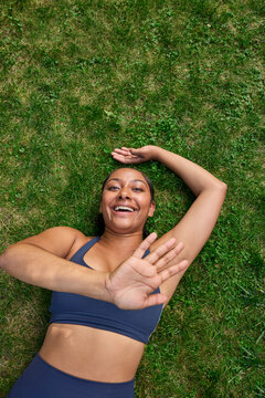 Young woman laying on grass laughing