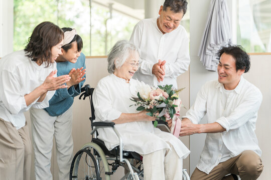 Three-generation family visiting a nursing home (presents, bouquet, Respect for the Aged Day)
