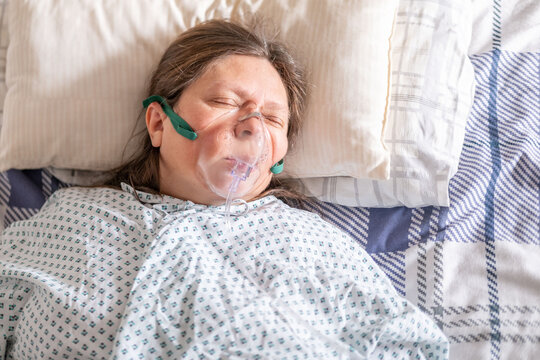 female patient in bed with oxygen mask, Human-centered health support, respiratory support, clinical ventilation interface obstructive sleep apnea treatment, medical breathing equipment in hospital