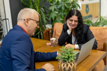 Fototapeta premium Business people discussing project on laptop in cafe