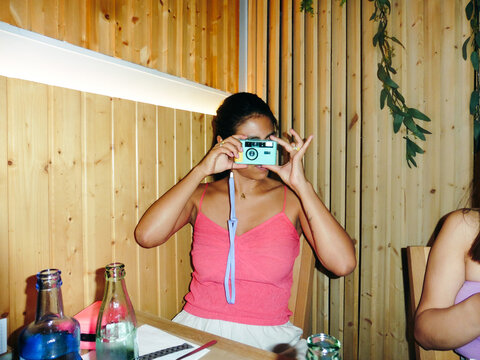 Woman Using Analog Camera at Restaurant