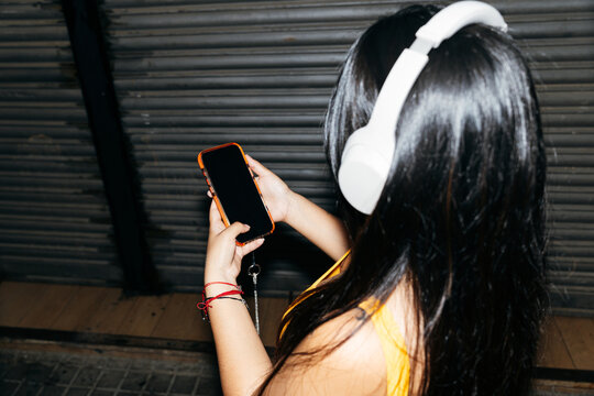 Woman Listening to Music Outdoors at Night