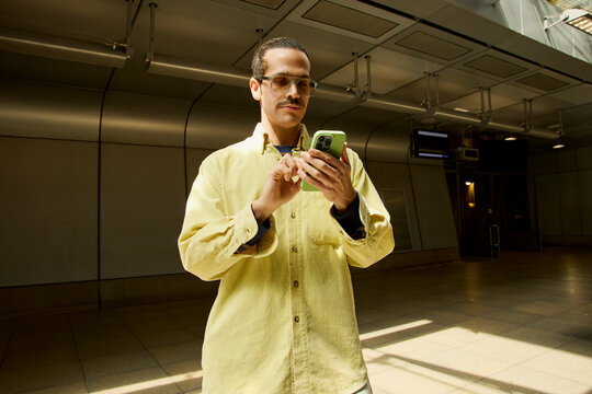  Man using smartphone inside London train station