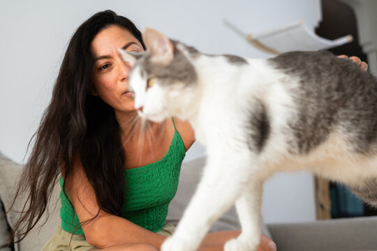 Woman Interacts With Her Playful Cat Indoors in a Cozy Setting
