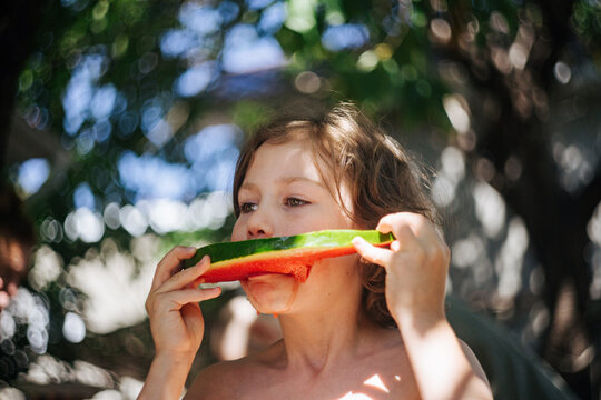 Little girl enjoying watermelon slices on summer afternoon