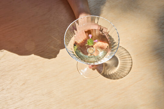 Overhead image of a woman with a cocktail at the table 