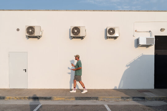 Man Walking by Air Conditioners