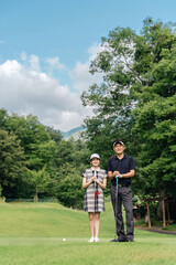 Obraz premium Male and female golfers on the golf course (golf classes, coaches, couples)