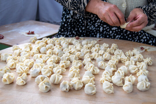hands making traditional Turkish dumplings on wood