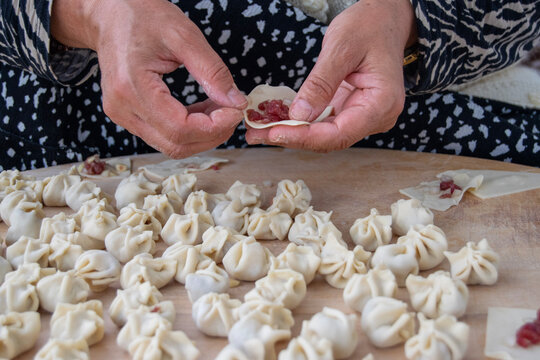 hands making traditional Turkish dumplings on wood