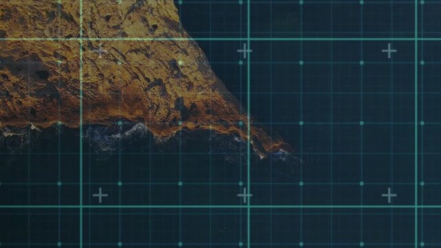 Teal grid activating, sliding and re-centering over rocky headland for mapping, foam forming at tip