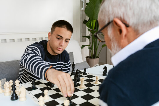 Teen plays chess with senior instructor