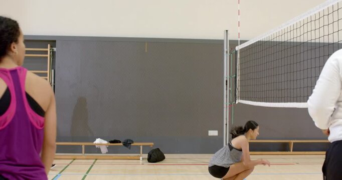 female volleyball setter in gym sprinting to net leaping overhead ball pass defending return