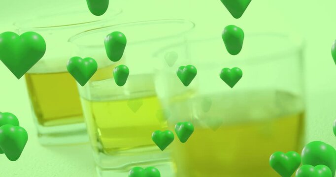 Green hearts drifting down, passing three glasses, camera sliding right, highlighting right glass