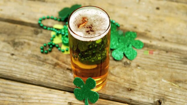 Camera shifting angle and zooming to show shamrocks, pint glass showing foam while highlights glint