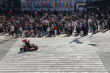 Fototapeta premium Shibuya Scramble Crossing, Tokyo, crowd of pedestrians and tourists walking on pedestrian crossing intersection during rush hour, Shibuya Station, Tokyo, Japan, passer-by walk in a sunny day