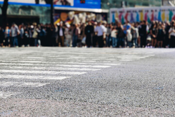 Obraz premium Shibuya Scramble Crossing, Tokyo, crowd of pedestrians and tourists walking on pedestrian crossing intersection during rush hour, Shibuya Station, Tokyo, Japan, passer-by walk in a sunny day