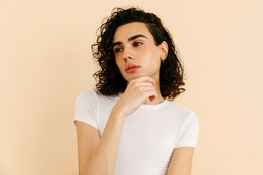 Queer man holding chin