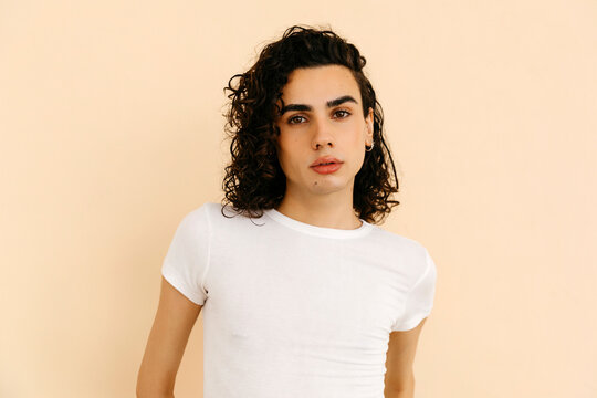 Curly-haired queer man  Poses Confidently in Studio 