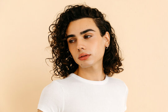 Queer man  with curly hair posing on