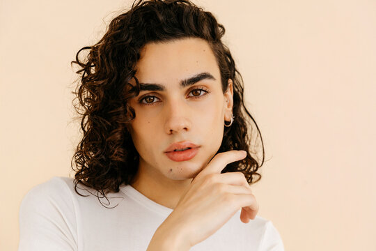 Queer man touching his face 