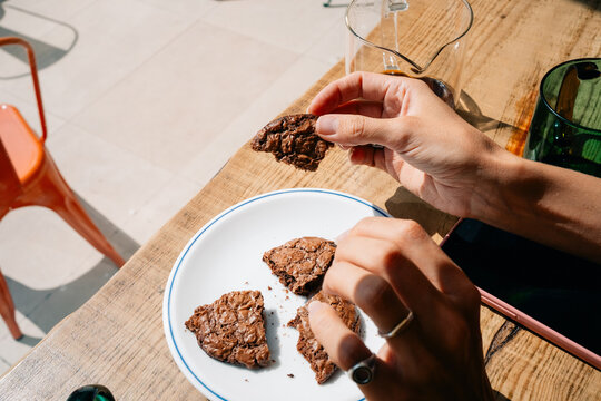 Person Holds a Delicious Chocolate Treat in a Cozy Cafe Setting