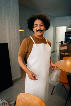 Smiling Person Wearing an Apron in a Modern Kitchen Setting