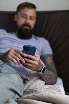 Bearded tattooed man checking news online