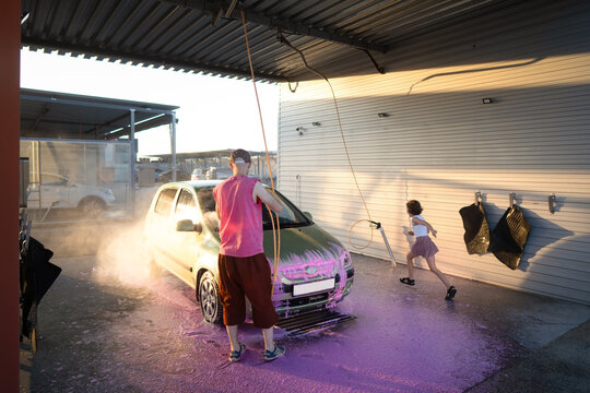Family teamwork washing car with foam