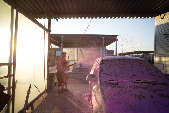 Dad and daughter washing shiny car