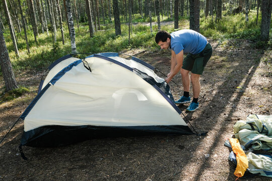 Setting up a Camping Tent in a Green Forest Landscape