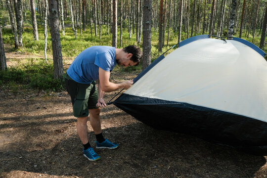 Setting up a Camping Tent in a Forest During Summer