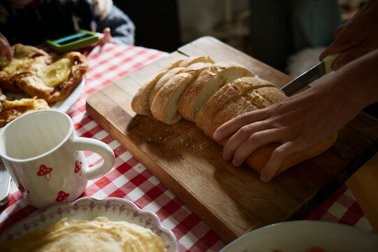 Preparing freshly sliced bread on a wooden cutting board
