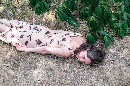 portrait of a woman lying under a tree