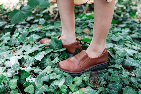 the legs of a woman standing by a tree are flattened