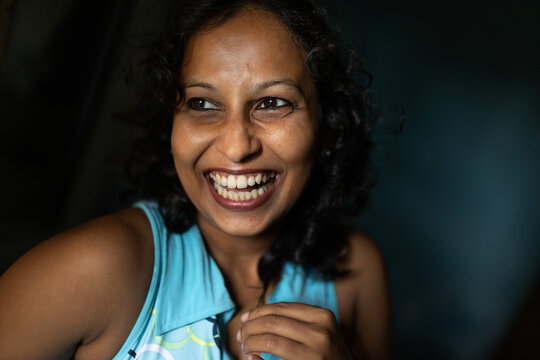 Indian woman laughing spontaneously inside home 