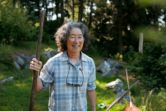 Smiling gardener holding a gardening tool and looking at camera